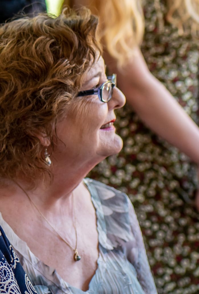 Profile of Kate Ronald smiling while watching Lisa Blankenship's wedding ceremony